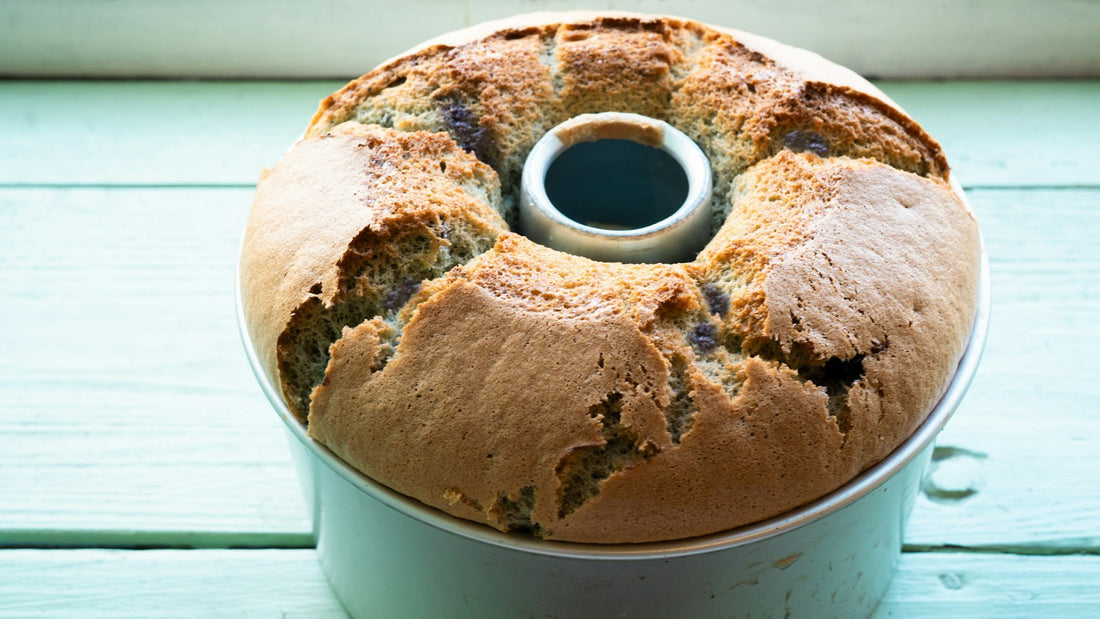 Gâteau doré tout juste sorti du four dans son moule rond, posé sur un plan de travail de cuisine clair
