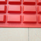 Gros plan sur les empreintes rectangulaires en silicone rouge