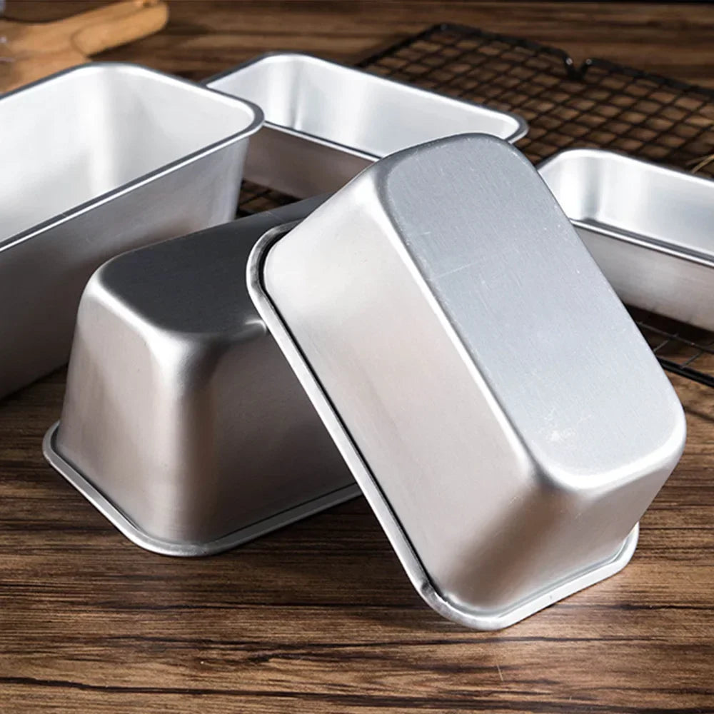 Moules à cake en aluminium sur un plan de travail en bois